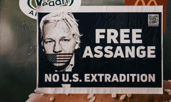 retrato de Assange con la boca tapada por una bandera de EEUU. Se lee FREE ASSANGE, no US extradition